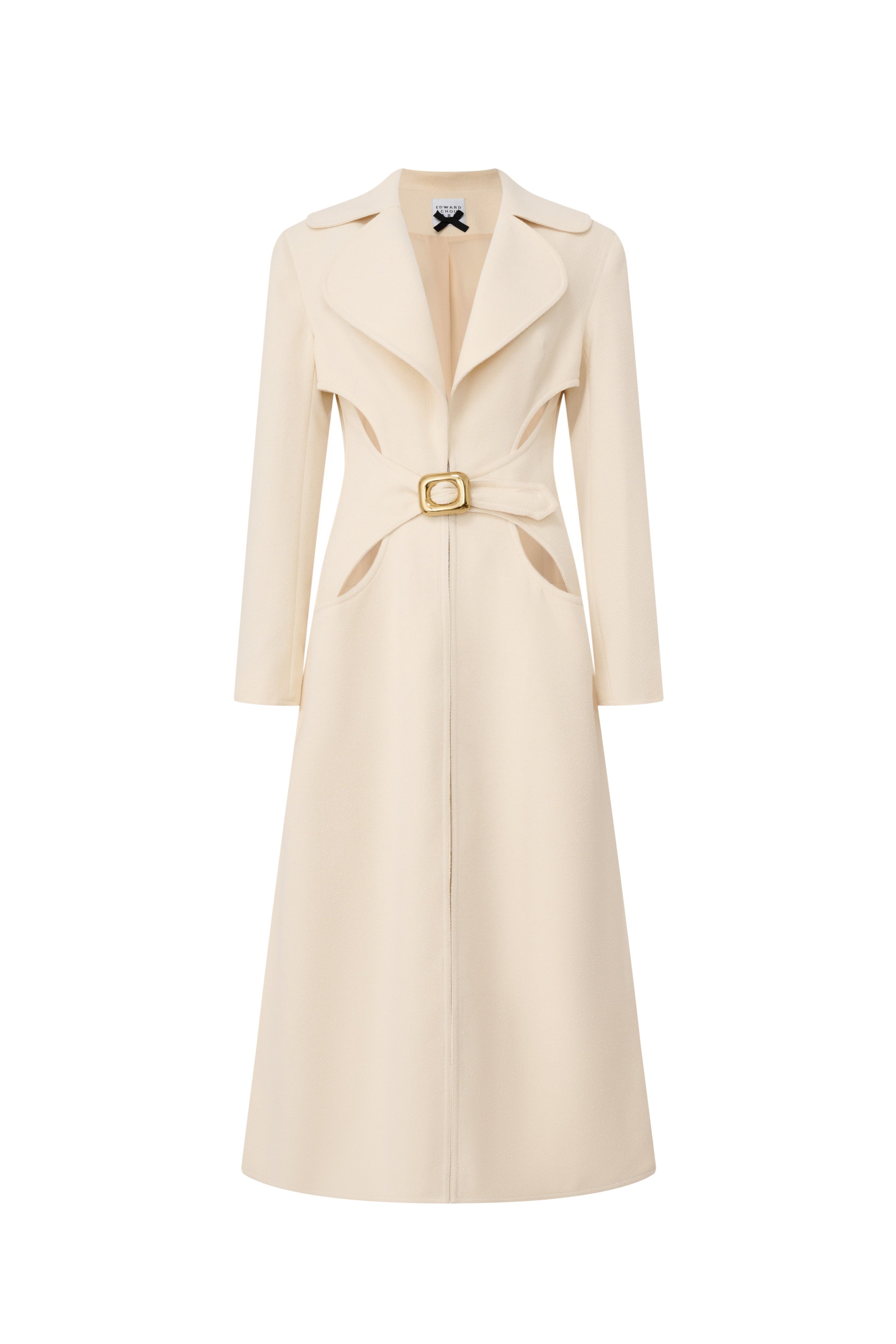 Front view of a long cream structured coat with waist cutouts and a gold buckle belt by Edward Achour.