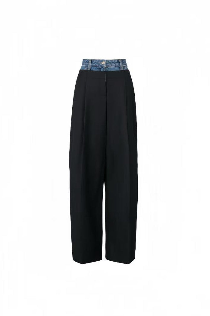 Front view of black tailored trousers with an integrated blue denim waistband.