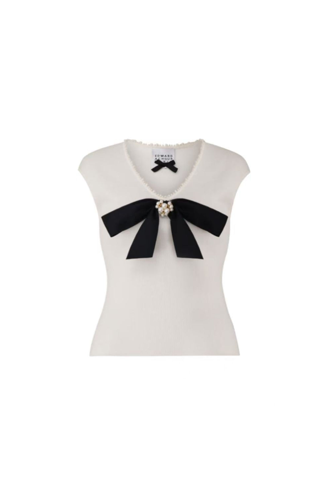 Front view of Edward Achour white knit top with a large black bow and pearl details.
