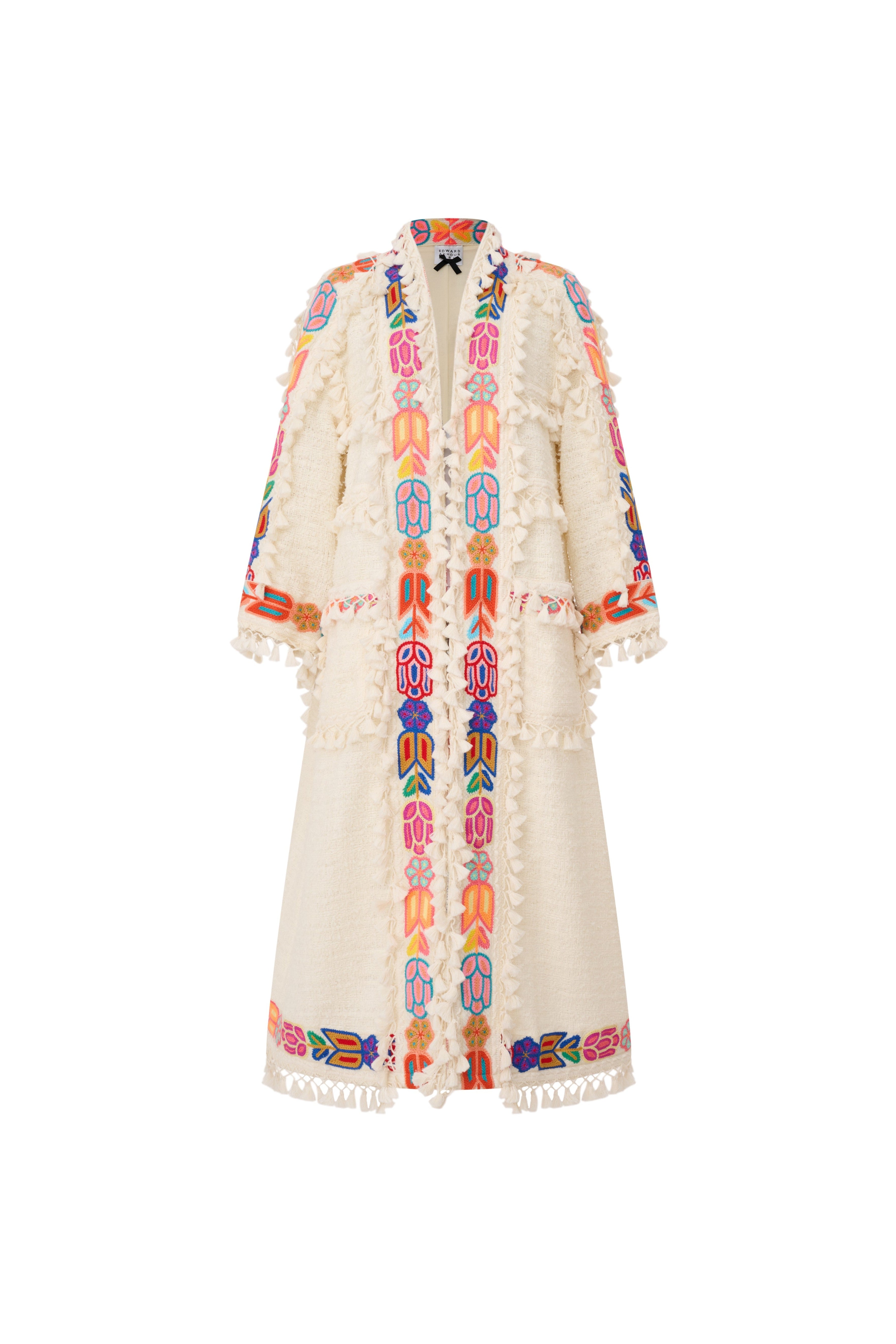 Full view of an oversized cream bouclé coat with a subtle A-line flare and colorful embroidery by Edward Achour.