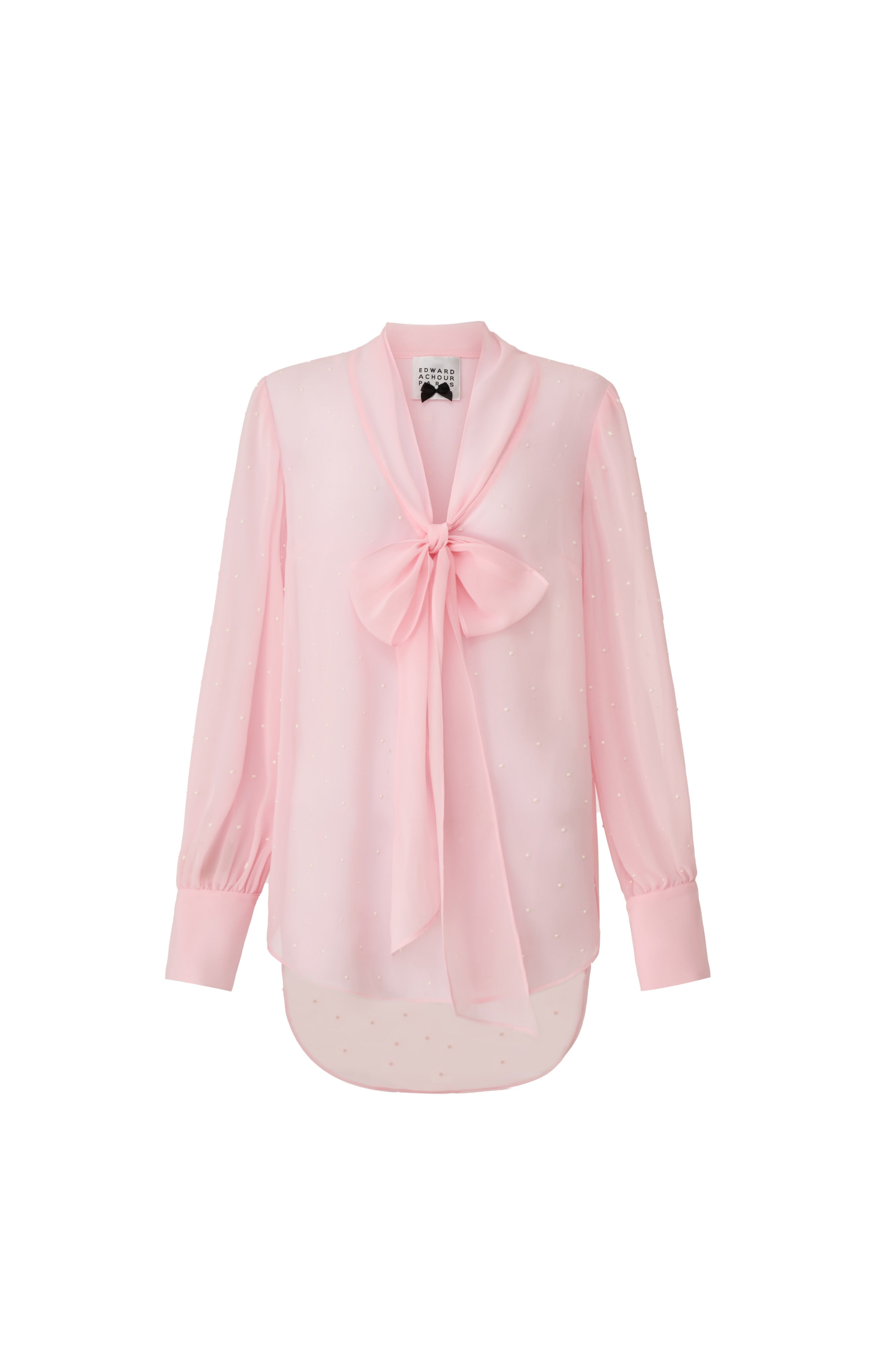 Front view of a pink shimmering sheer blouse with a large bow by Edward Achour Paris.