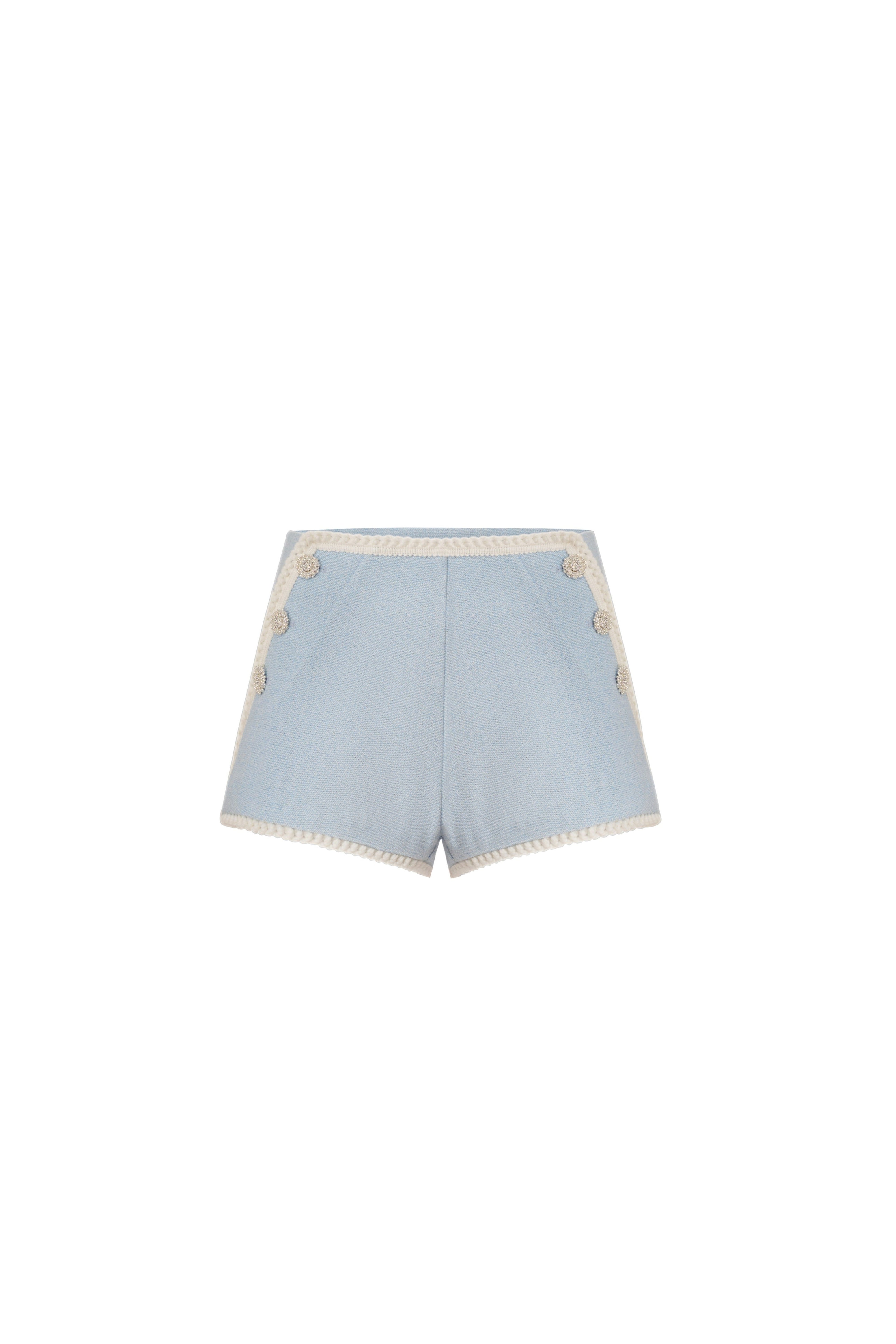 Front view of light blue high-waisted shorts with cream crochet trim and side buttons.